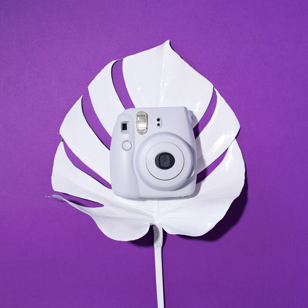 Vilnius, Lithuania - September 16, 2019: FUJIFILM INSTAX Mini Instant Film Camera on violet